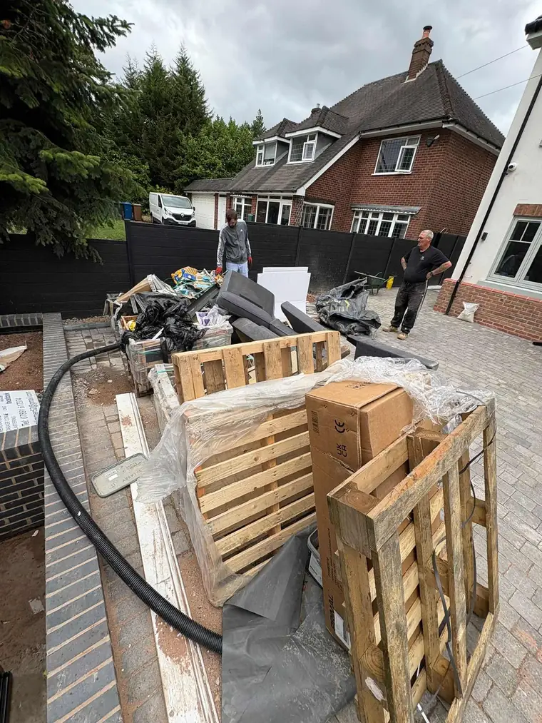 A large renovation clearance with pallets, old furniture and boxes loaded from a driveway
